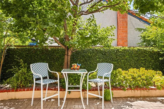 a patio with table and chairs and potted plants