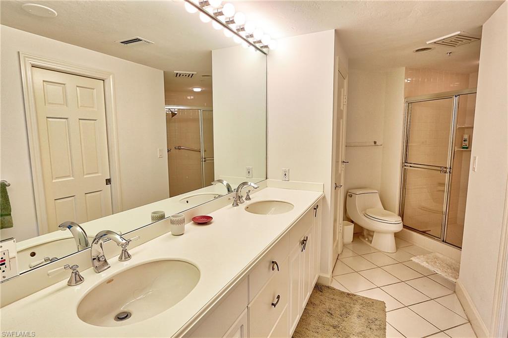 60 Seagate Drive, Unit 805 Naples, FL 34103 - Photo 17 of 29 a bathroom with a double vanity sink mirror and toilet
