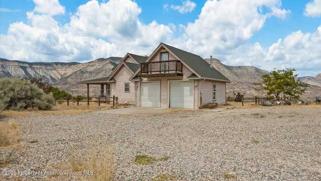 a front view of a house with a dirt yard and garage
