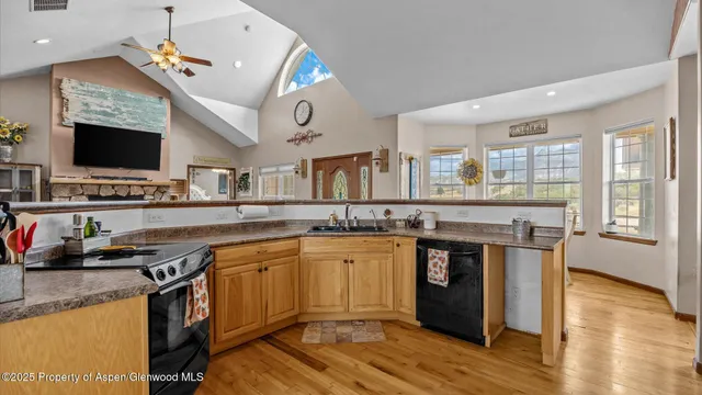 a kitchen with stainless steel appliances granite countertop a stove and a wooden floors