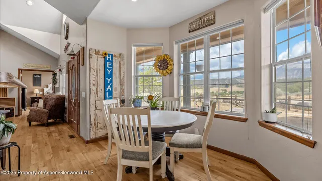 a dining room with furniture a chandelier and wooden floor