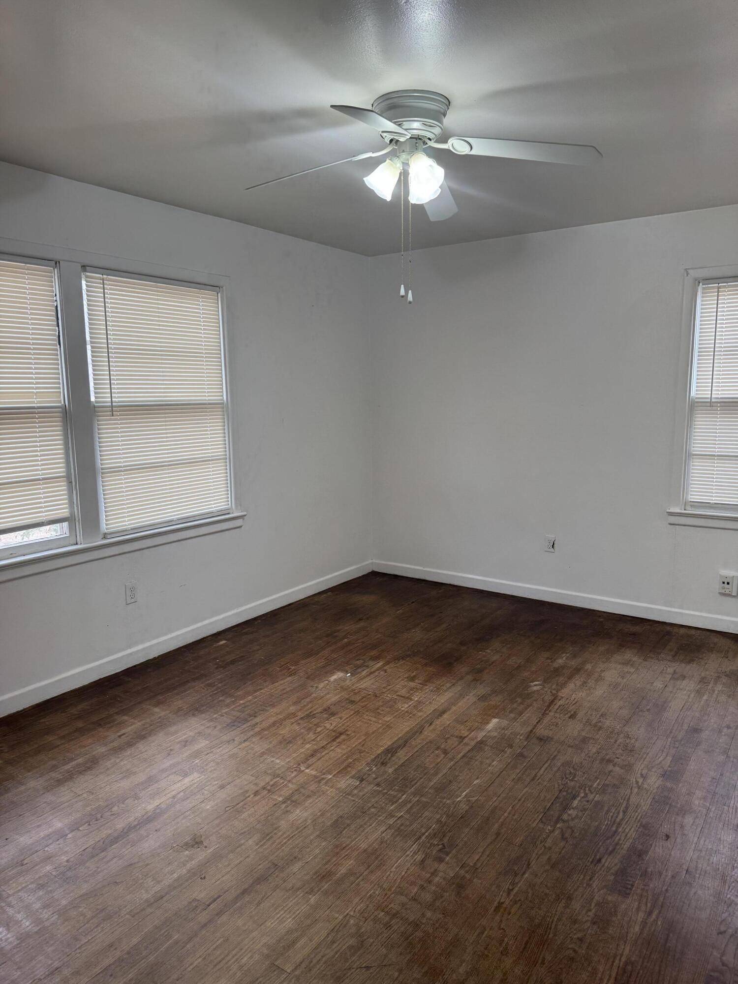 2514 43rd Street Lubbock, TX 79413 - Photo 6 of 8 an empty room with a chandelier fan and windows