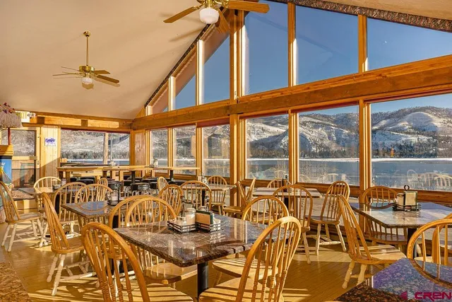 a view of a dining room with furniture one side kitchen view and chandelier