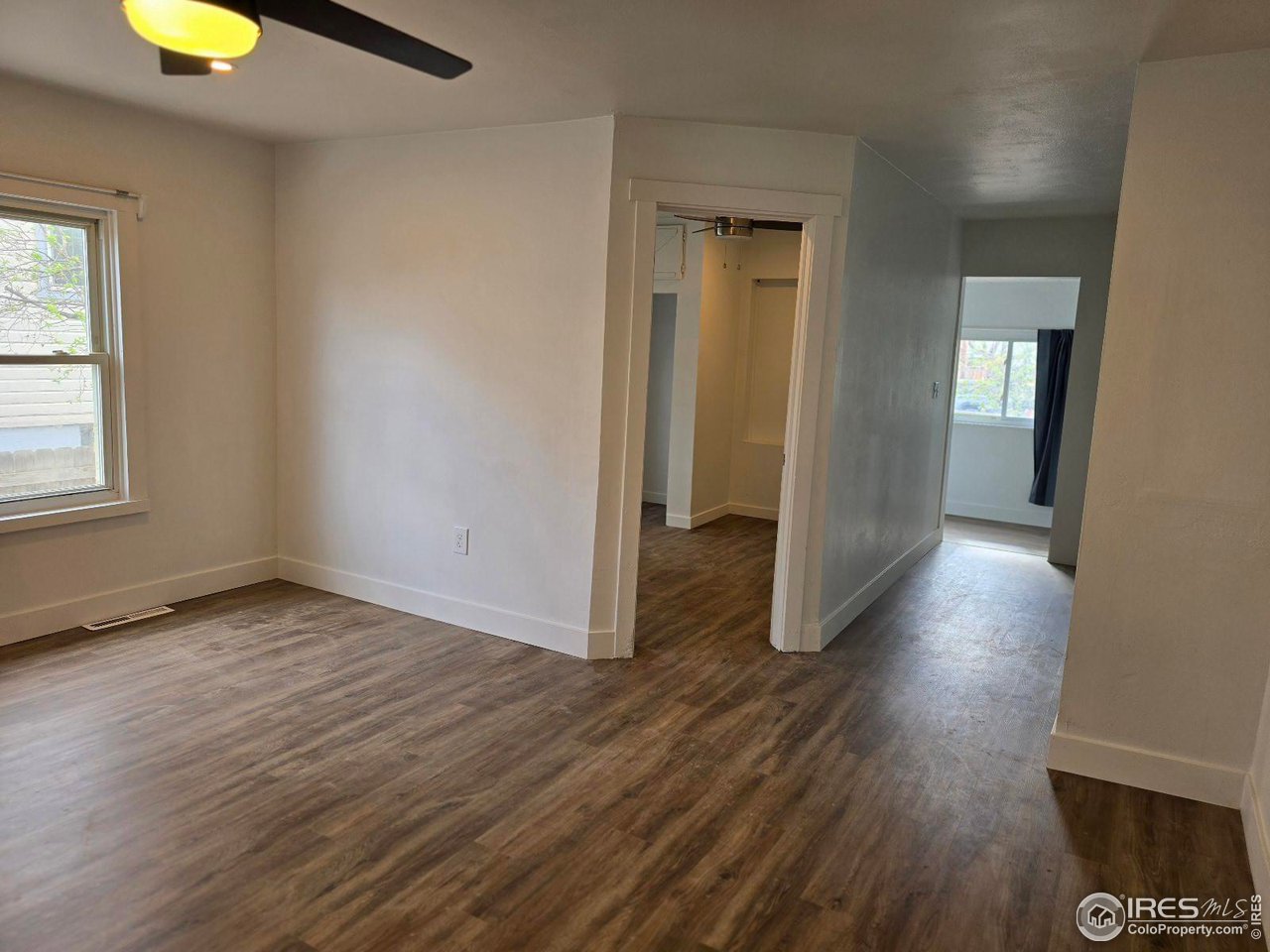 1324 7th Avenue Greeley, CO 80631 - Photo 12 of 22 an empty room with wooden floor and windows