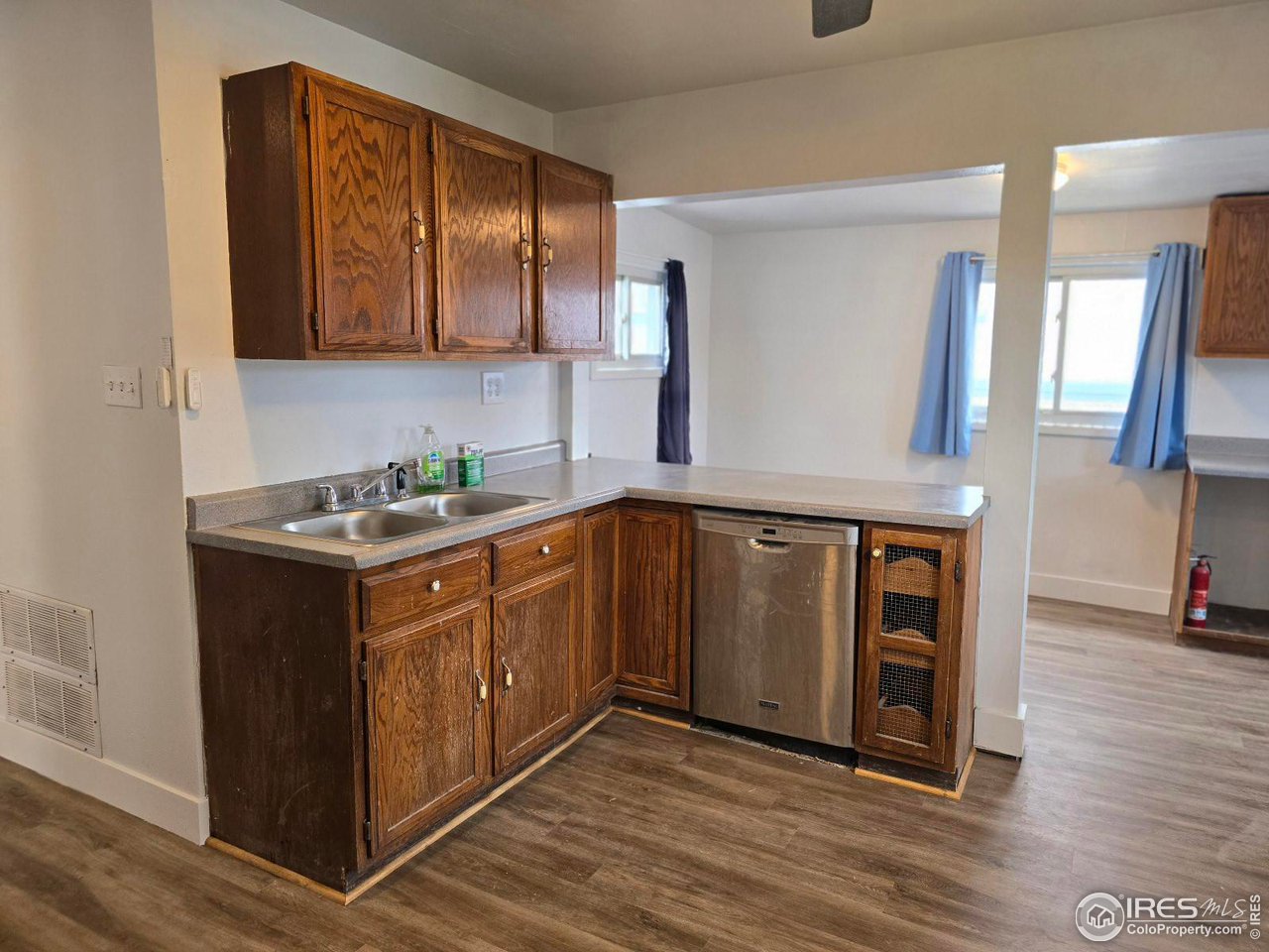 1324 7th Avenue Greeley, CO 80631 - Photo 19 of 22 a kitchen with stainless steel appliances granite countertop a sink a stove and a wooden floors