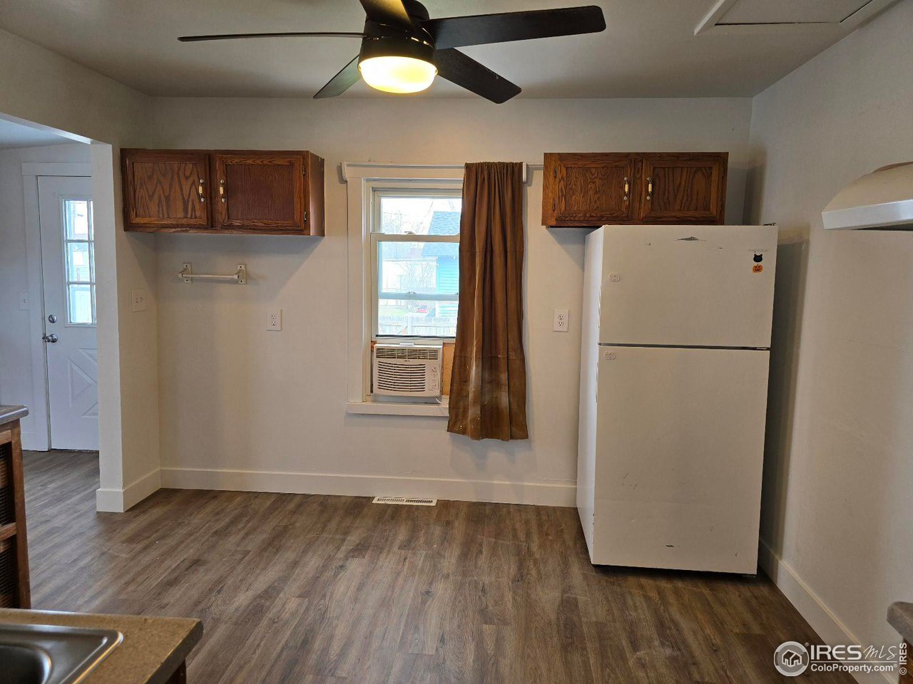 1324 7th Avenue Greeley, CO 80631 - Photo 20 of 22 a view of a kitchen with wooden floor and a refrigerator