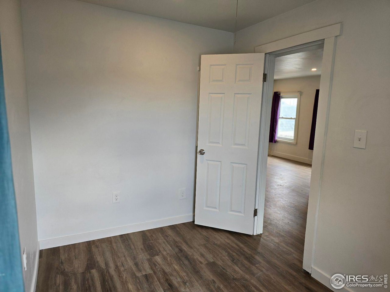 1324 7th Avenue Greeley, CO 80631 - Photo 4 of 22 a view of an empty room with wooden floor and closet