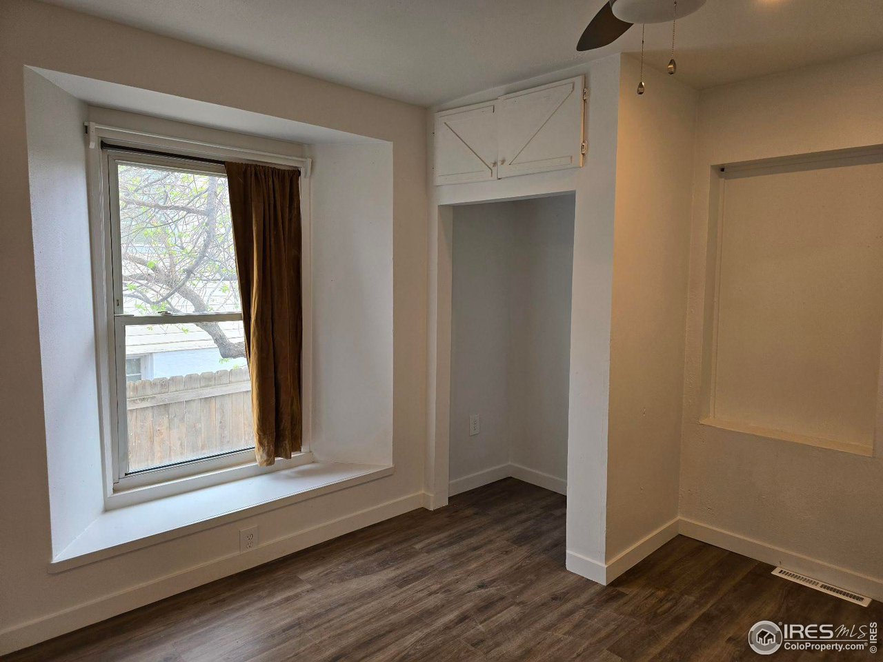 1324 7th Avenue Greeley, CO 80631 - Photo 5 of 22 a view of an empty room with wooden floor and a window