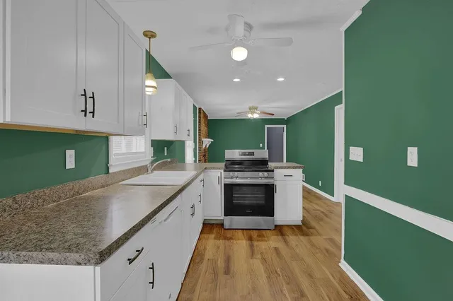 a kitchen with stainless steel appliances granite countertop a sink a stove and a refrigerator