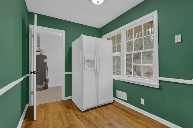 a view of empty room with wooden floor and windows