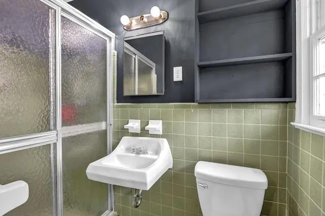 a bathroom with a toilet a sink and a mirror