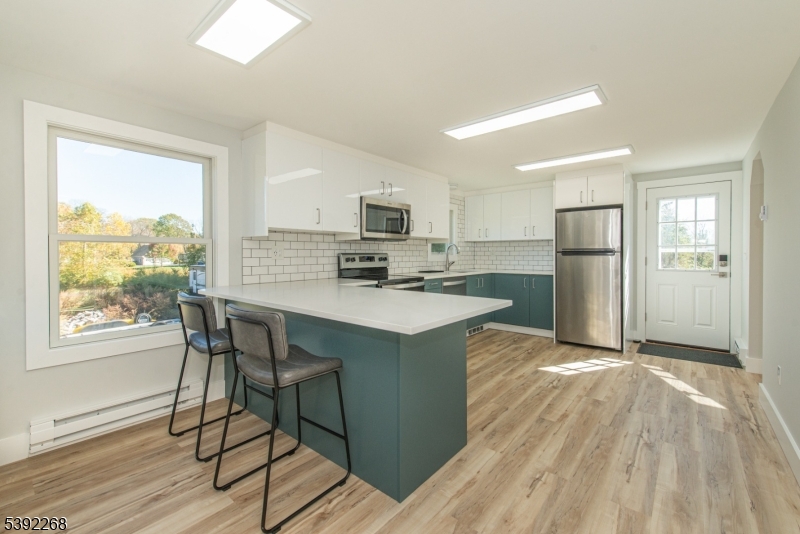 a kitchen with refrigerator cabinets and wooden floor