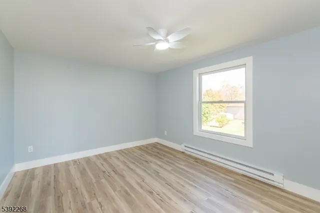 an empty room with a window and a ceiling fan