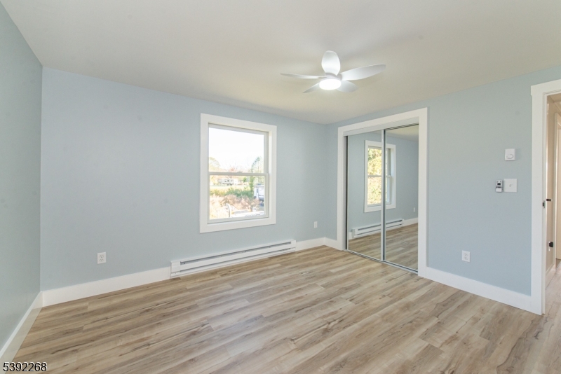 23 George Hill Road Augusta, NJ 07822 - Photo 12 of 19 an empty room with wooden floor fan and windows