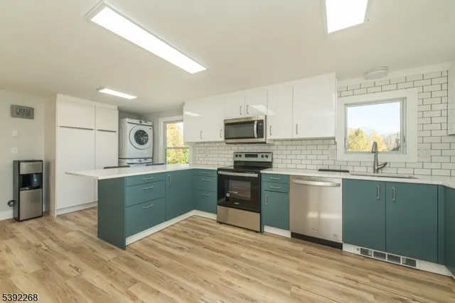 a kitchen with granite countertop a refrigerator stove top oven and sink
