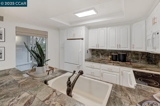 a kitchen with stainless steel appliances granite countertop a sink stove and cabinets