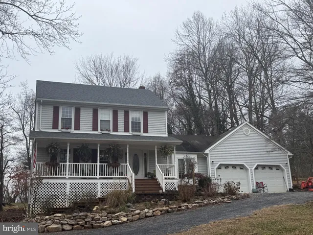 a front view of a house with yard and trees in the background