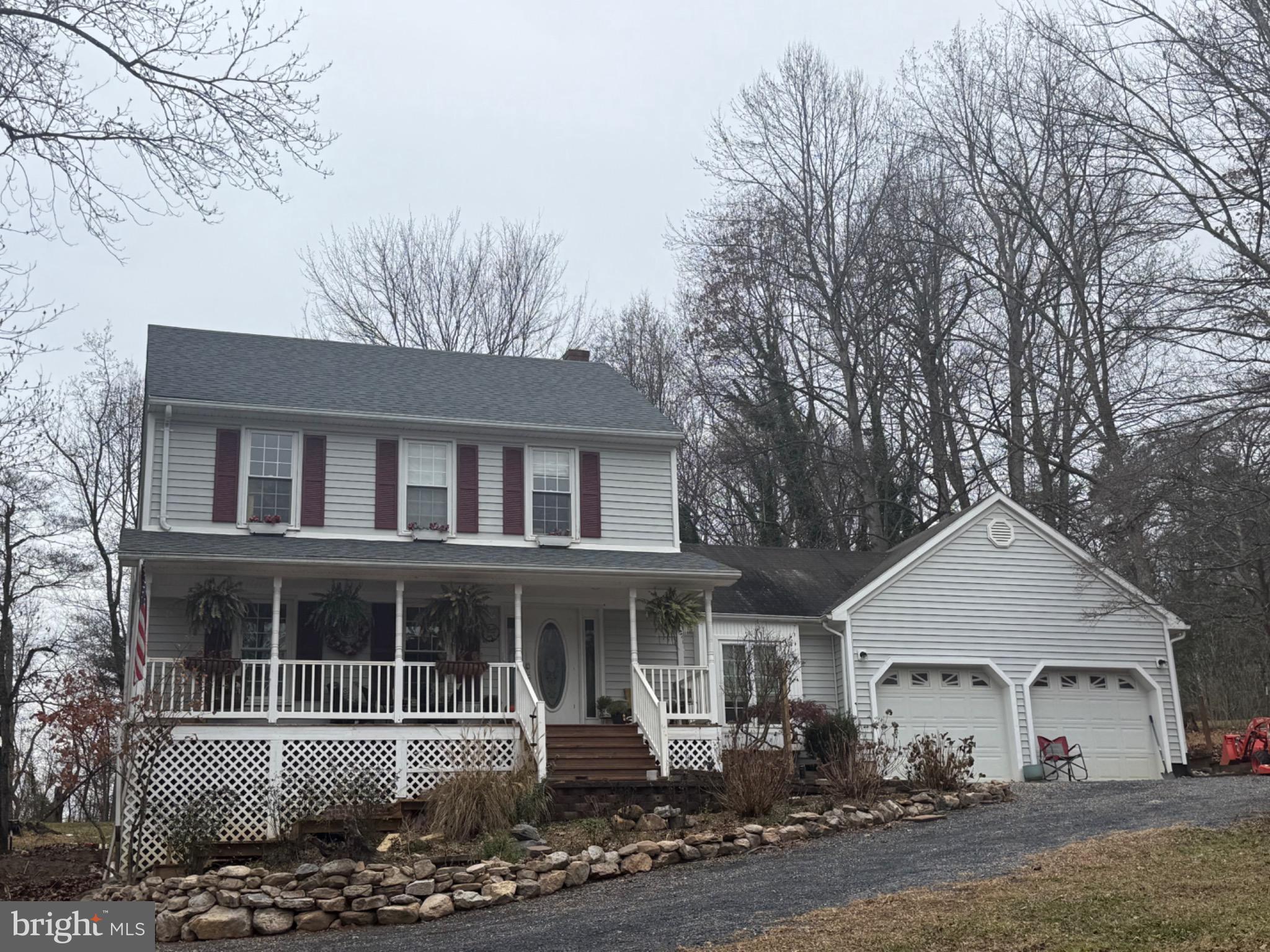 a front view of a house with yard and trees in the background
