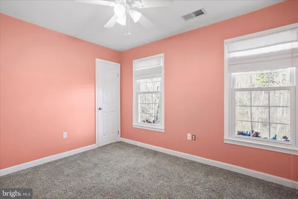 an empty room with a ceiling fan and a window