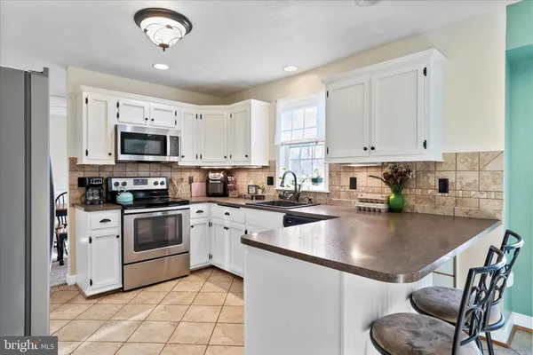 a kitchen with stainless steel appliances granite countertop a refrigerator and a sink