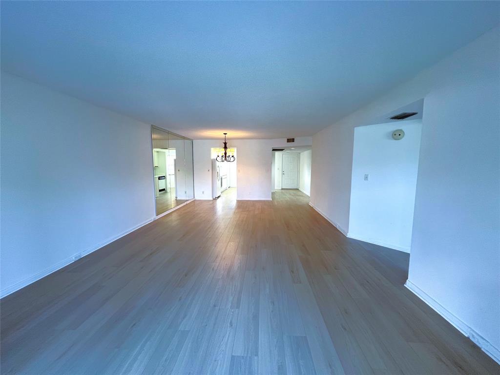 1803 Eleuthera Point, Unit J2 Coconut Creek, FL 33066 - Photo 11 of 27 a view of a big room with wooden floor and windows