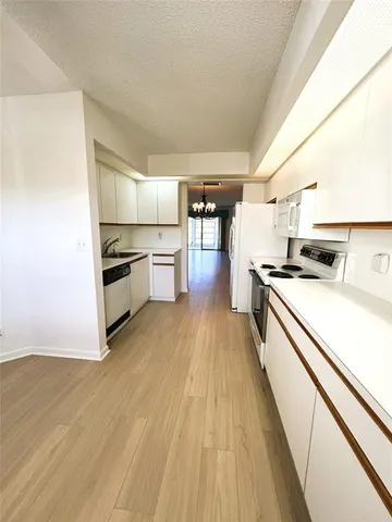 a kitchen with granite countertop a stove and a refrigerator