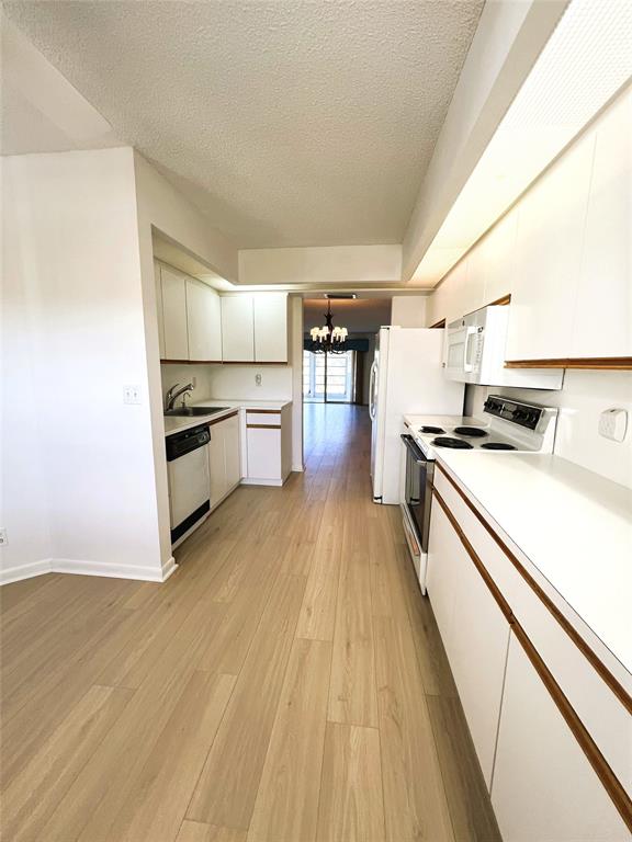 1803 Eleuthera Point, Unit J2 Coconut Creek, FL 33066 - Photo 2 of 27 a kitchen with granite countertop a stove and a refrigerator