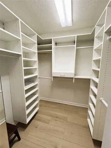 a view of walk in closet with empty racks