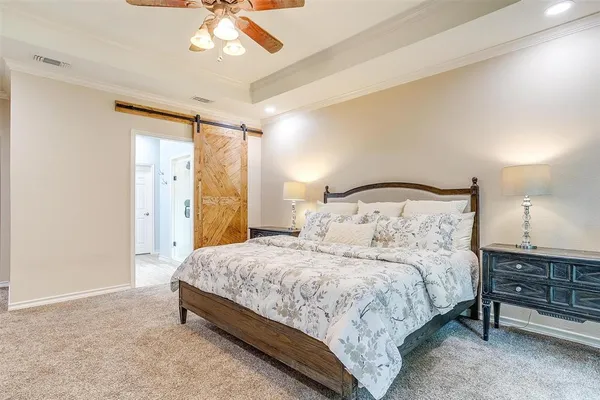 a bedroom with a bed and a flat screen tv on dresser