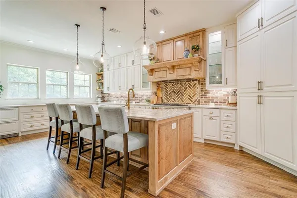 a kitchen with white cabinets and sink