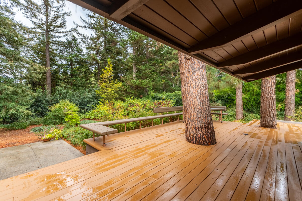 a backyard of a house with wooden floor and outdoor seating