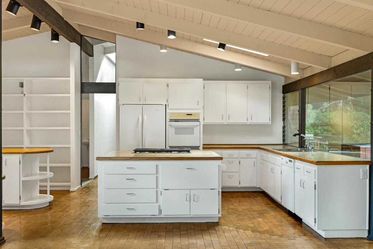 1681 East Valley Road Montecito, CA 93108 - Photo 11 of 61 a kitchen with stainless steel appliances granite countertop a sink and cabinets with wooden floor
