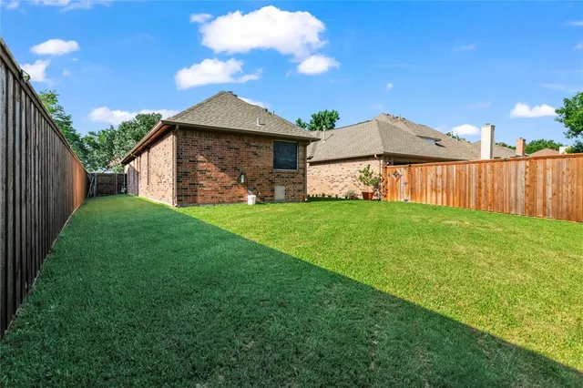 a view of a yard with a large tree in front of it