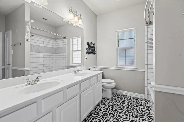 a bathroom with a sink toilet a mirror and shower