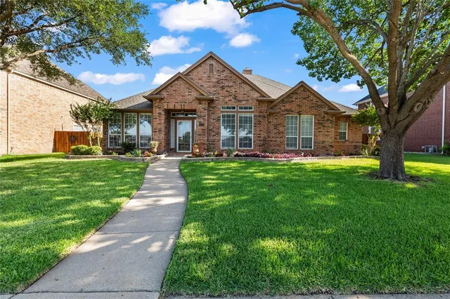 a front view of a house with a yard and trees