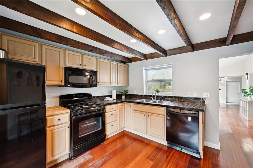 642 Filmore Road Pittsburgh, PA 15221 - Photo 7 of 30 a kitchen with stainless steel appliances granite countertop a stove a sink and a microwave