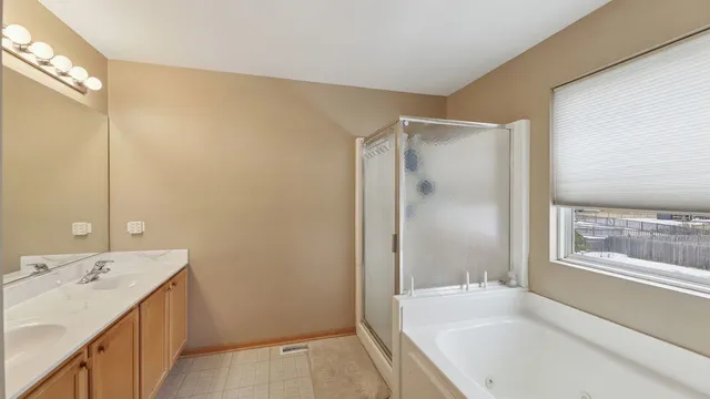 a bathroom with a tub sink and mirror