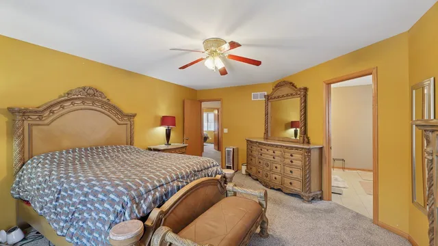 a bedroom with a bed and dresser with mirror