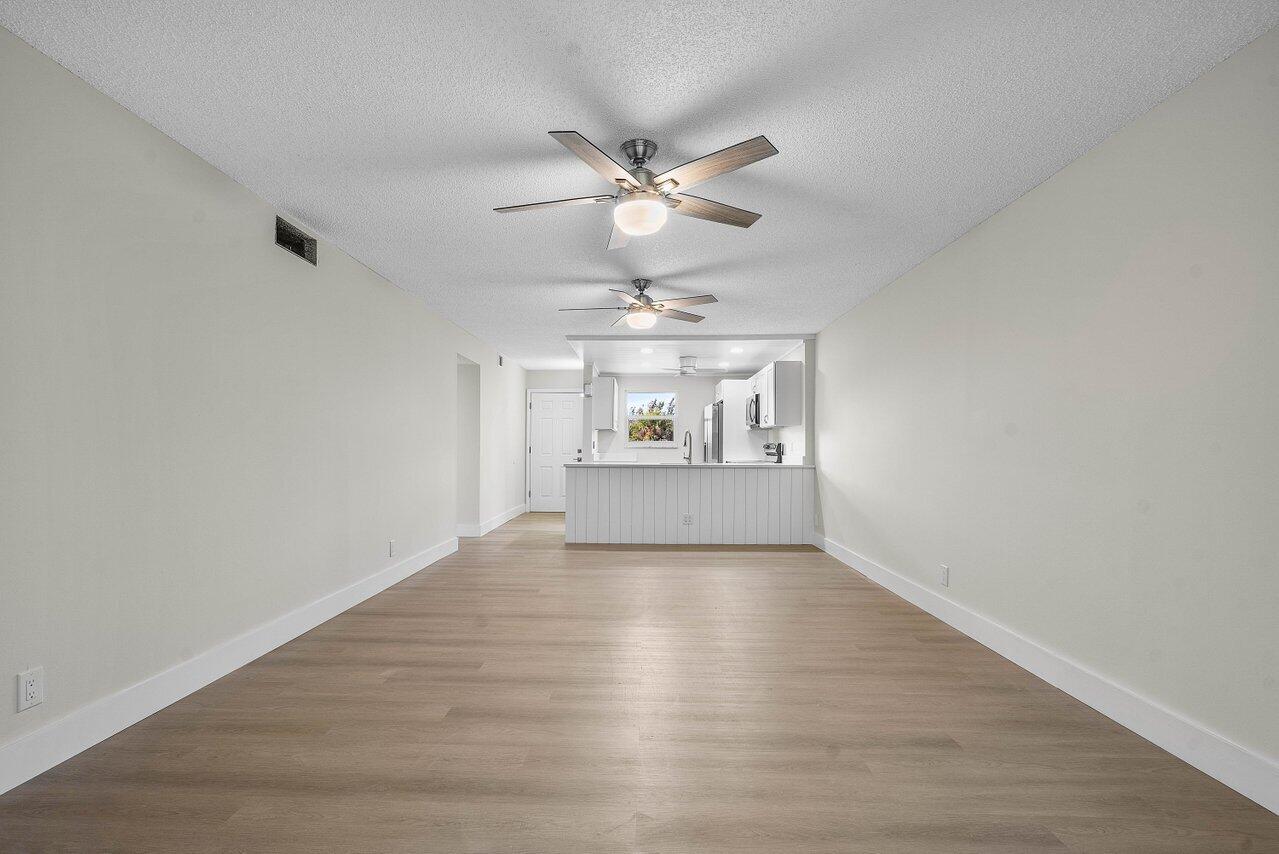 2601 Northeast 3rd Street, Unit 3040 Boynton Beach, FL 33435 - Photo 11 of 24 a view of a livingroom with a ceiling fan and wooden floor
