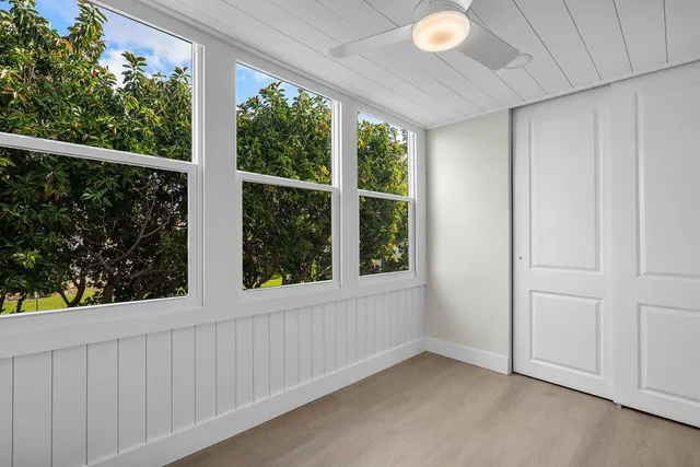a view of an empty room with a window and hardwood floor