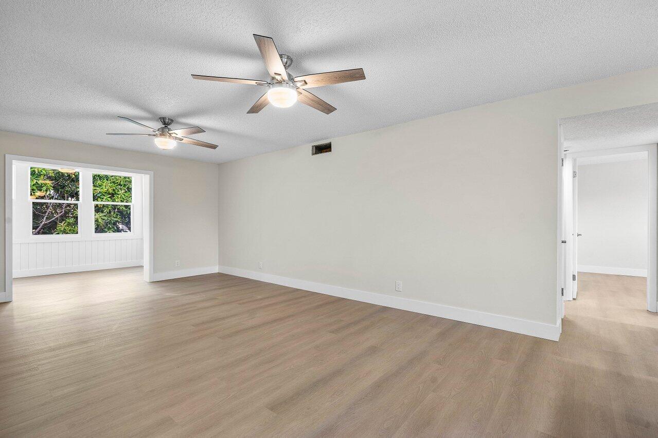 2601 Northeast 3rd Street, Unit 3040 Boynton Beach, FL 33435 - Photo 15 of 24 an empty room with wooden floor chandelier fan and windows