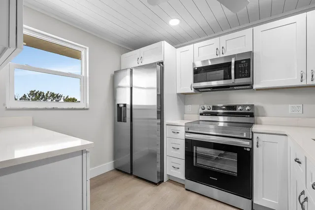 a kitchen with stainless steel appliances a stove a microwave and cabinets