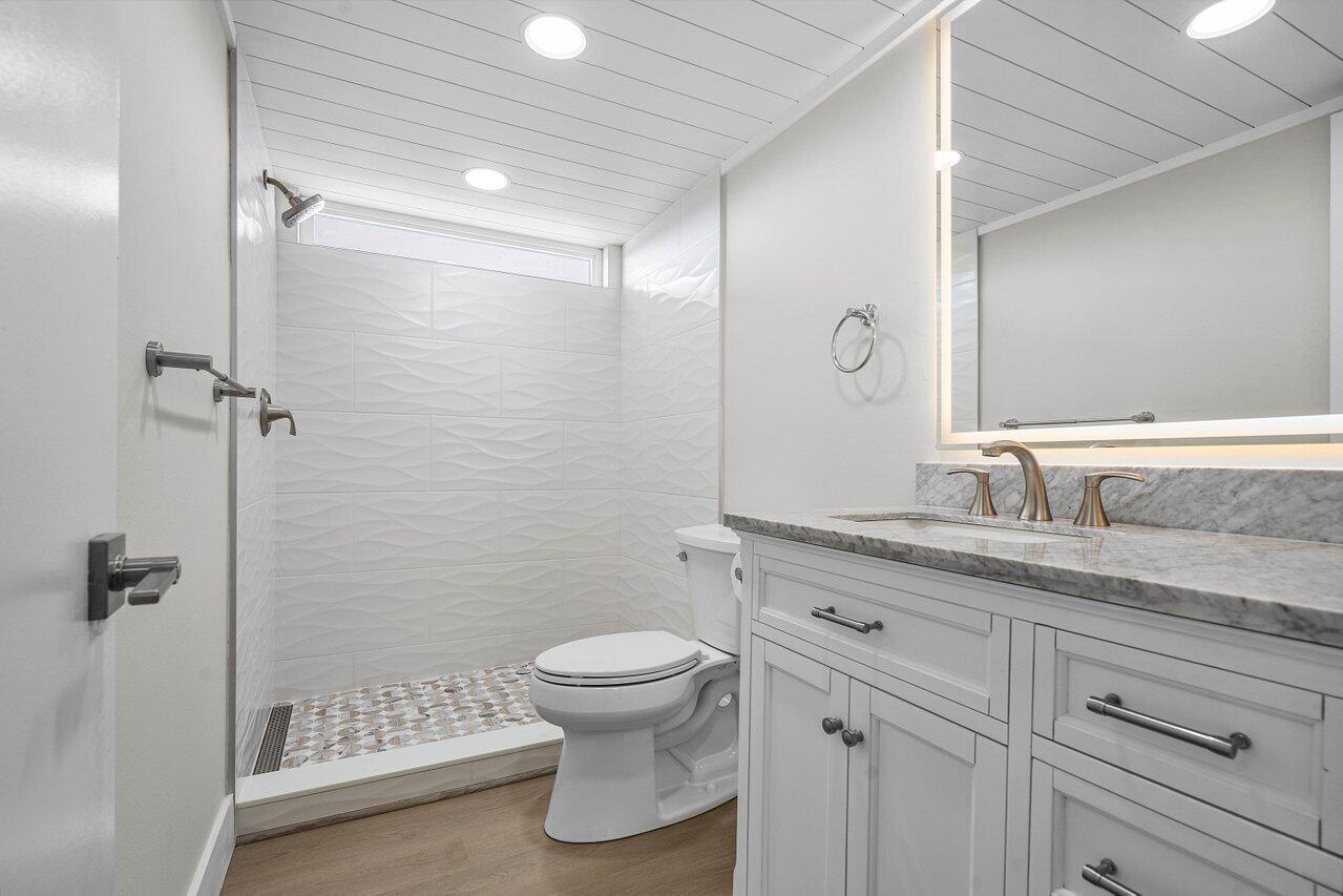 2601 Northeast 3rd Street, Unit 3040 Boynton Beach, FL 33435 - Photo 22 of 24 a bathroom with a granite countertop sink a toilet and shower