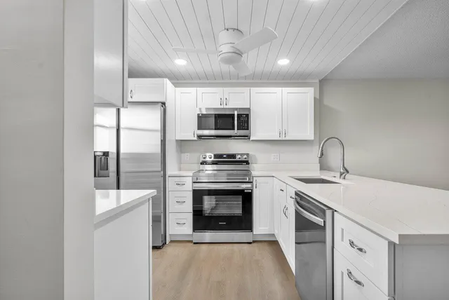 a kitchen with stainless steel appliances granite countertop a sink and a stove top oven