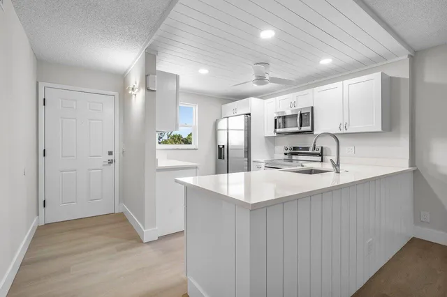 a kitchen with kitchen island sink stove and refrigerator