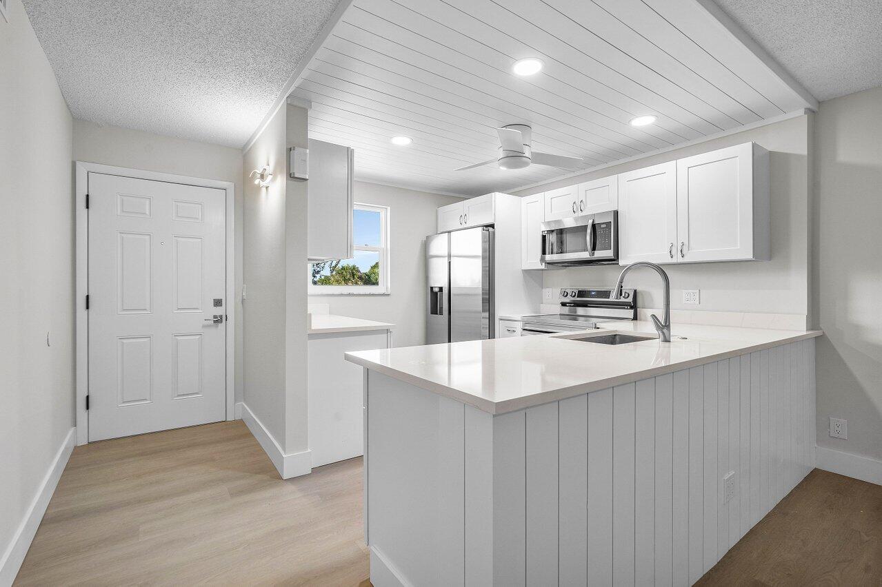 2601 Northeast 3rd Street, Unit 3040 Boynton Beach, FL 33435 - Photo 6 of 24 a kitchen with kitchen island sink stove and refrigerator