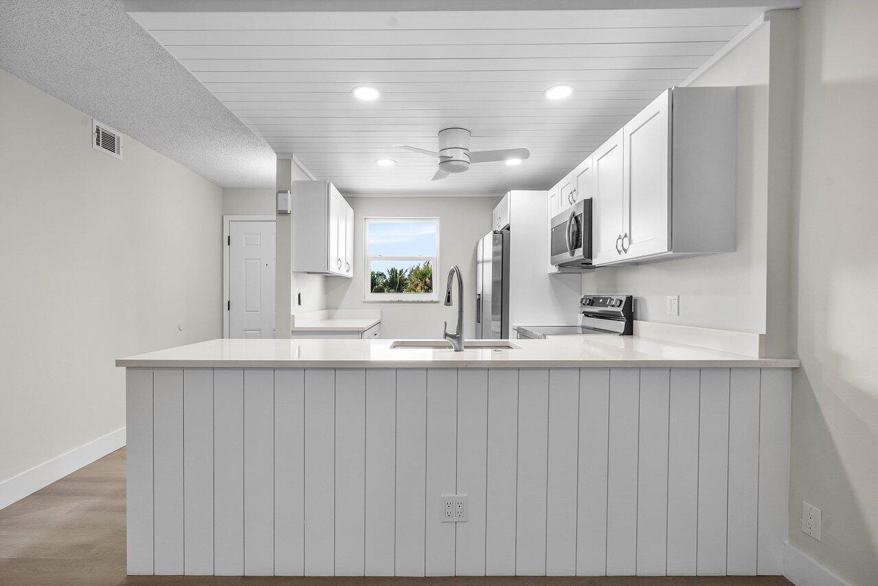 2601 Northeast 3rd Street, Unit 3040 Boynton Beach, FL 33435 - Photo 7 of 24 a kitchen with kitchen island a sink stainless steel appliances and cabinets