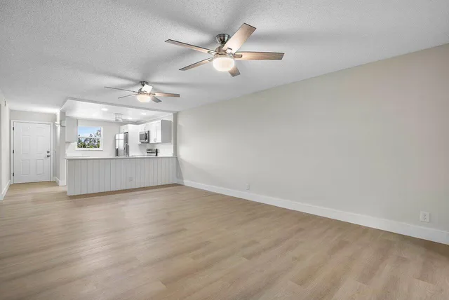 a view of a livingroom with a ceiling fan and wooden floor