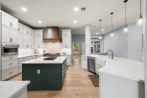 a kitchen with kitchen island a sink stainless steel appliances and cabinets