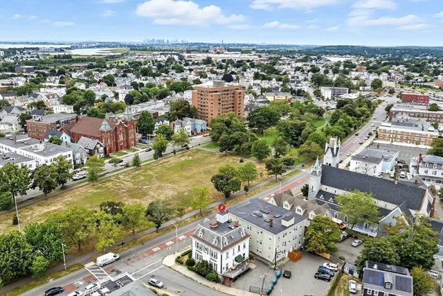 an aerial view of residential houses with outdoor space and ocean view